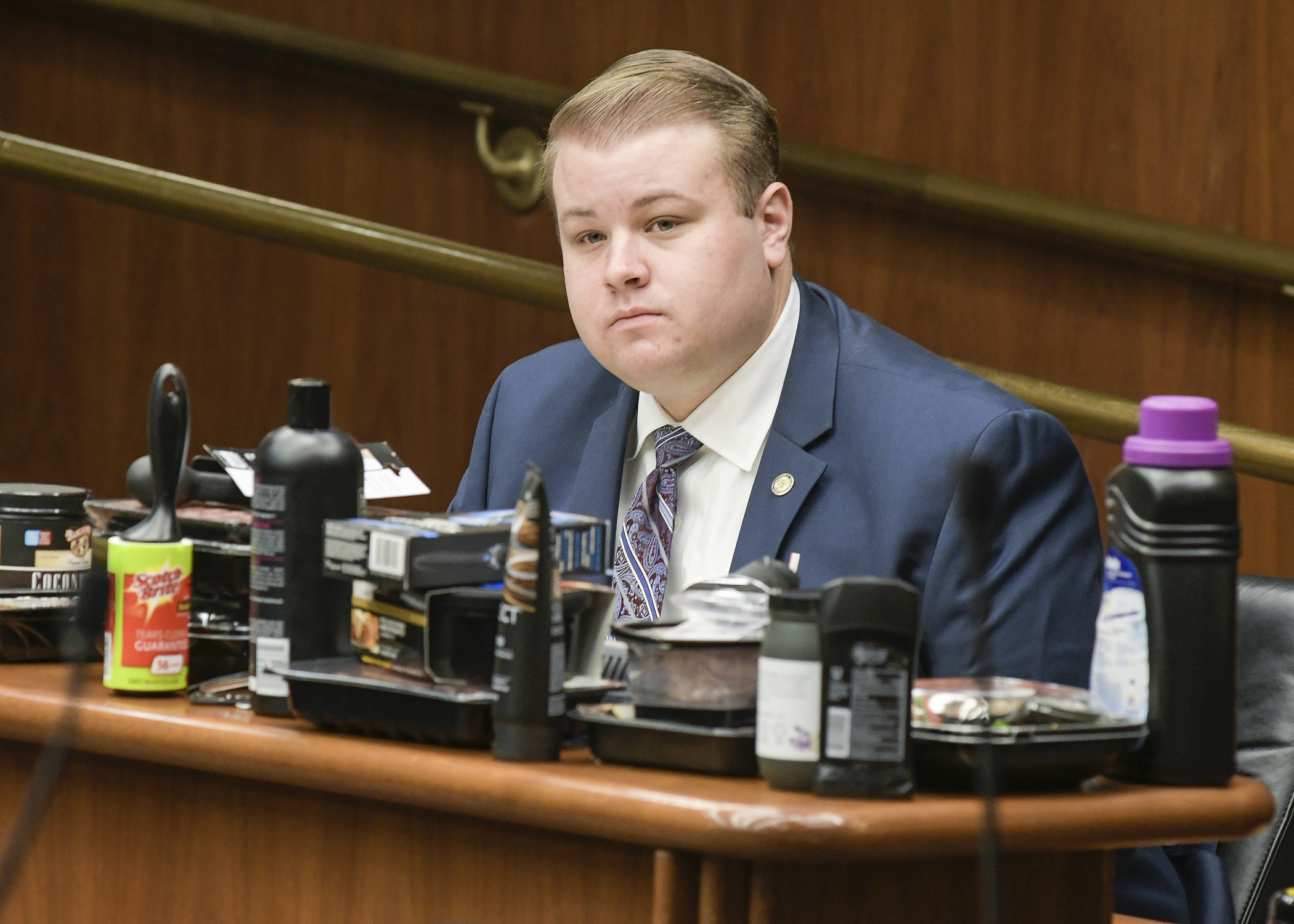 Surrounded by recyclable black plastic products banned by some cities, Rep. Drew Christensen testifies March 28 on a bill he sponsors that would prohibit counties, cities and towns from regulating auxiliary containers. Photo by Andrew VonBank